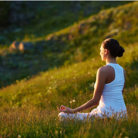 Person practicing yoga at an eco-friendly villa surrounded by nature in Corbett.